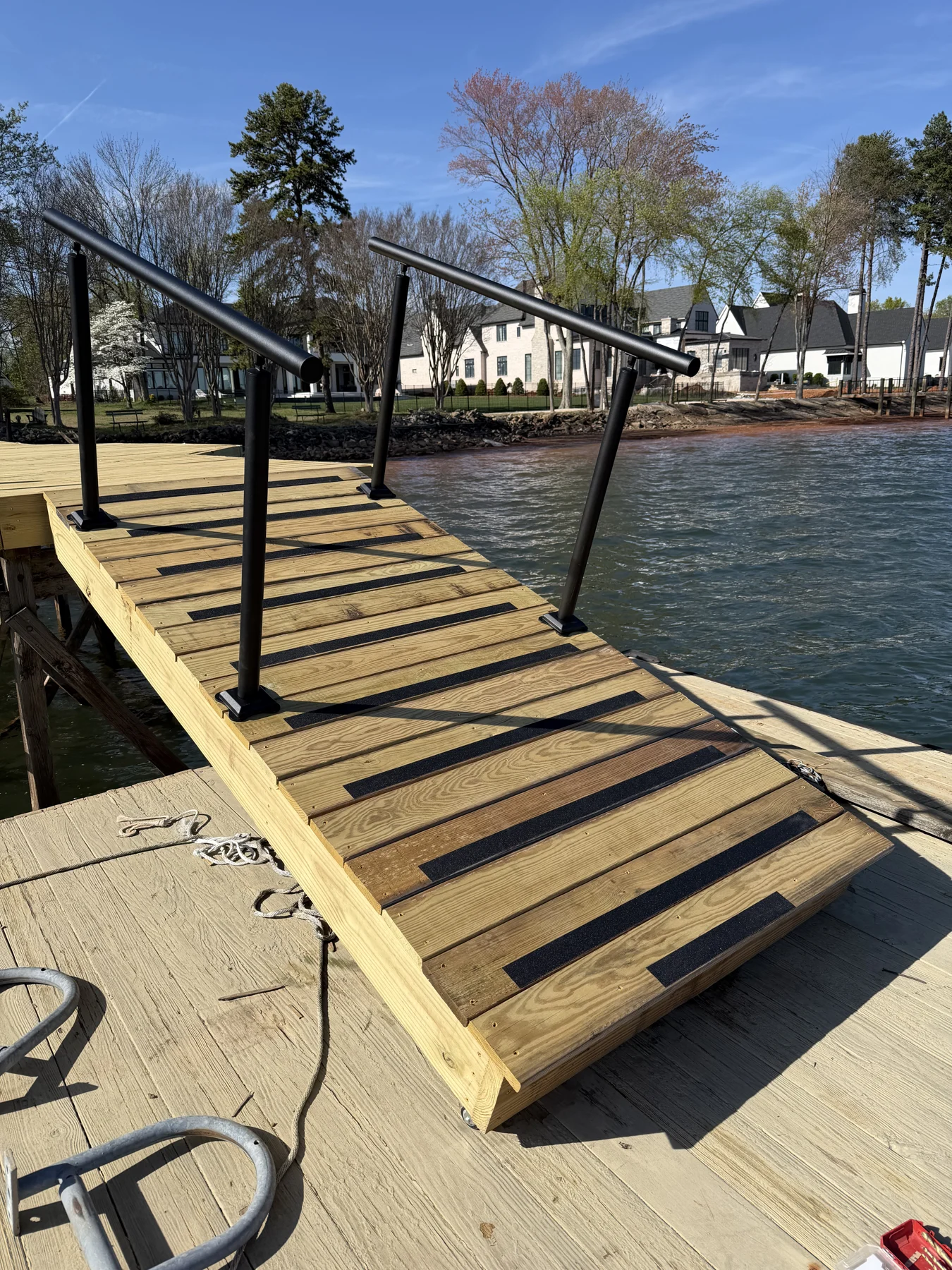 A waterfront dock construction journal showing the timber frame and access stairs beside the water. These are progress photographs of the structure before its finished walking surface.