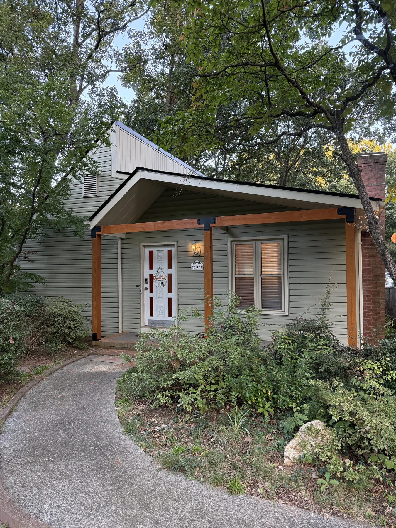 Exterior work at a small garden building with a pitched roof, glazed doors and windows. The gallery shows the building and the crew working along its exterior roof and trim line.
