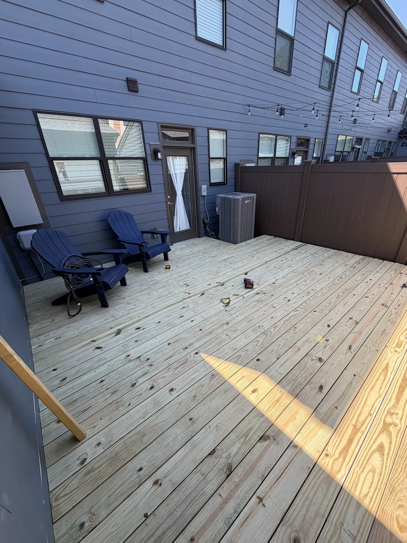 A small timber landing takes shape outside the back door. These progress photographs show the boards, underlying framing and work area at the home&rsquo;s entrance.