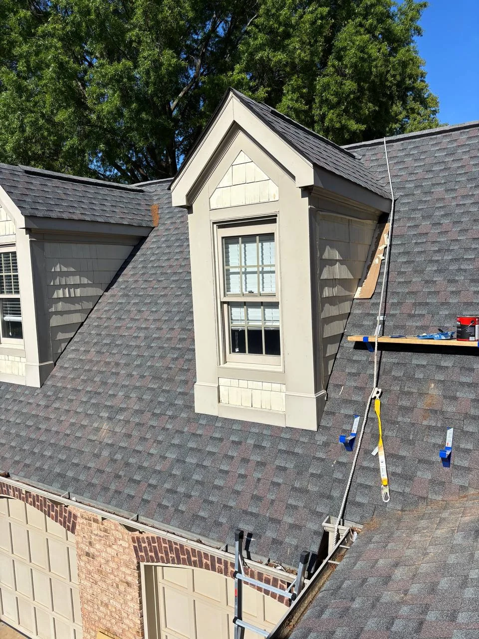 Exterior carpentry around a roof dormer, including the window surround, siding and adjoining roof details. Close photographs show the work area and the finished architectural lines.