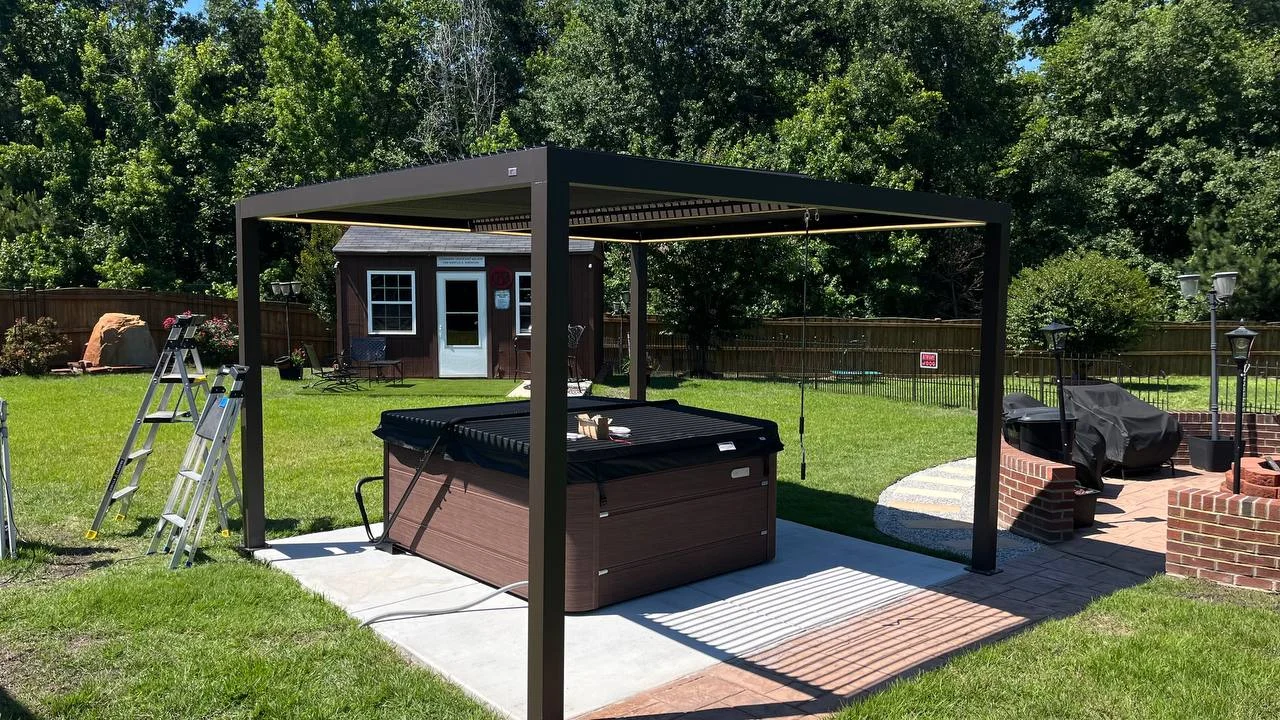 A dark pergola defines the backyard gathering area beside a hot tub. Overall views and an overhead detail show the open roof arrangement and the structure&rsquo;s relationship to the surrounding outdoor space.