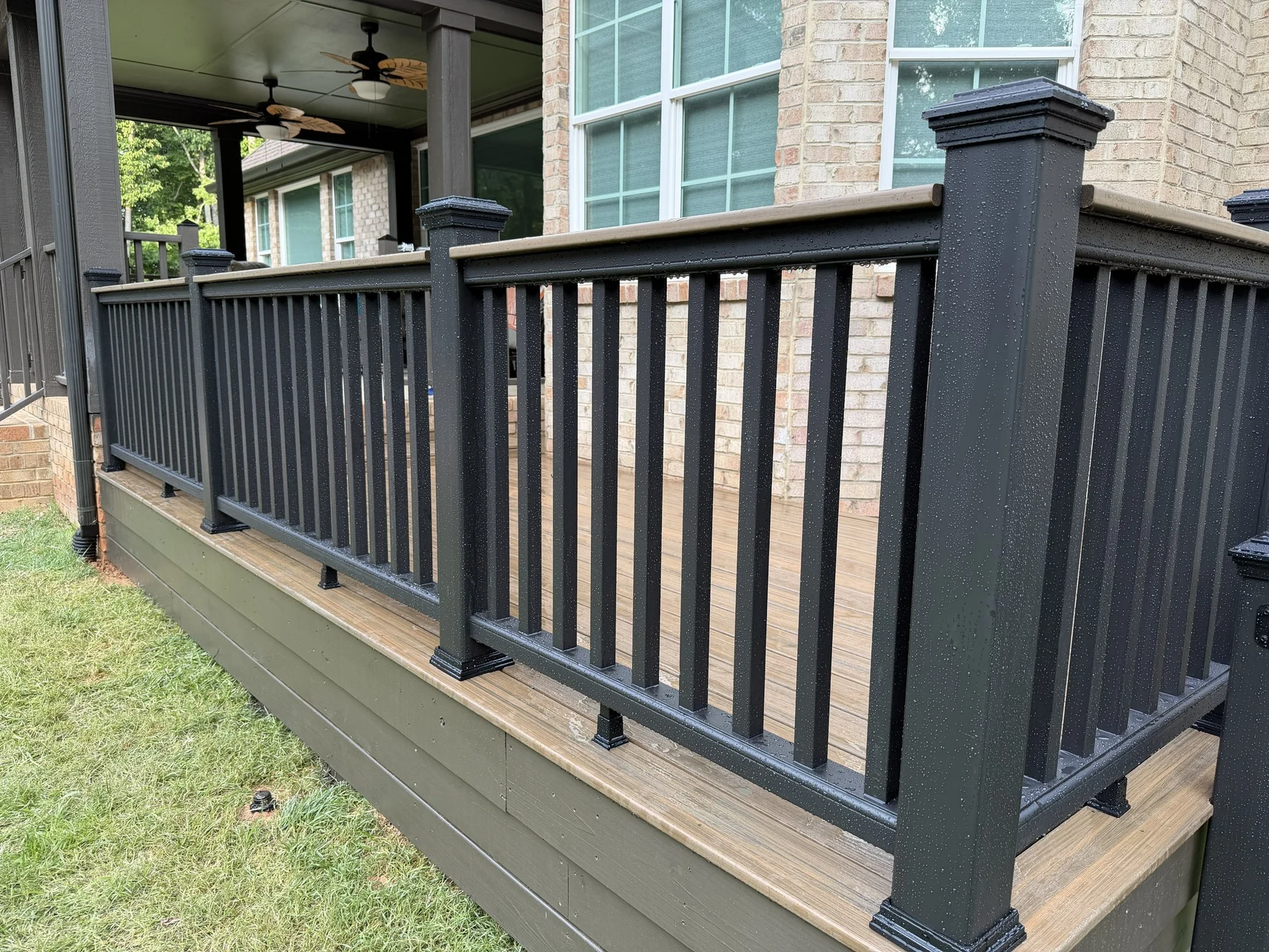 Trex Toasted Sand decking follows the home&rsquo;s complex footprint. Broad, low-rise steps and careful transitions create a natural connection to the covered porch.
