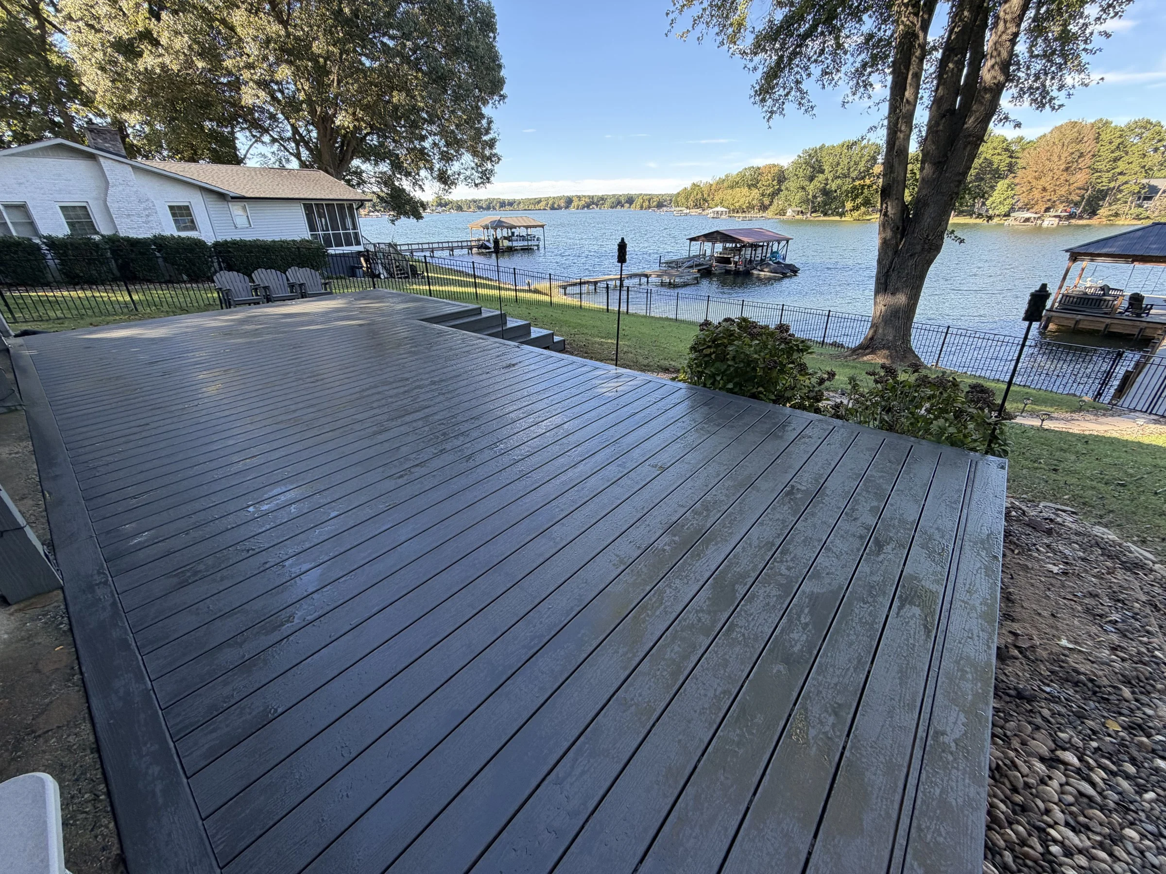 Finished decking with aligned boards and a picture-frame perimeter beside the home.